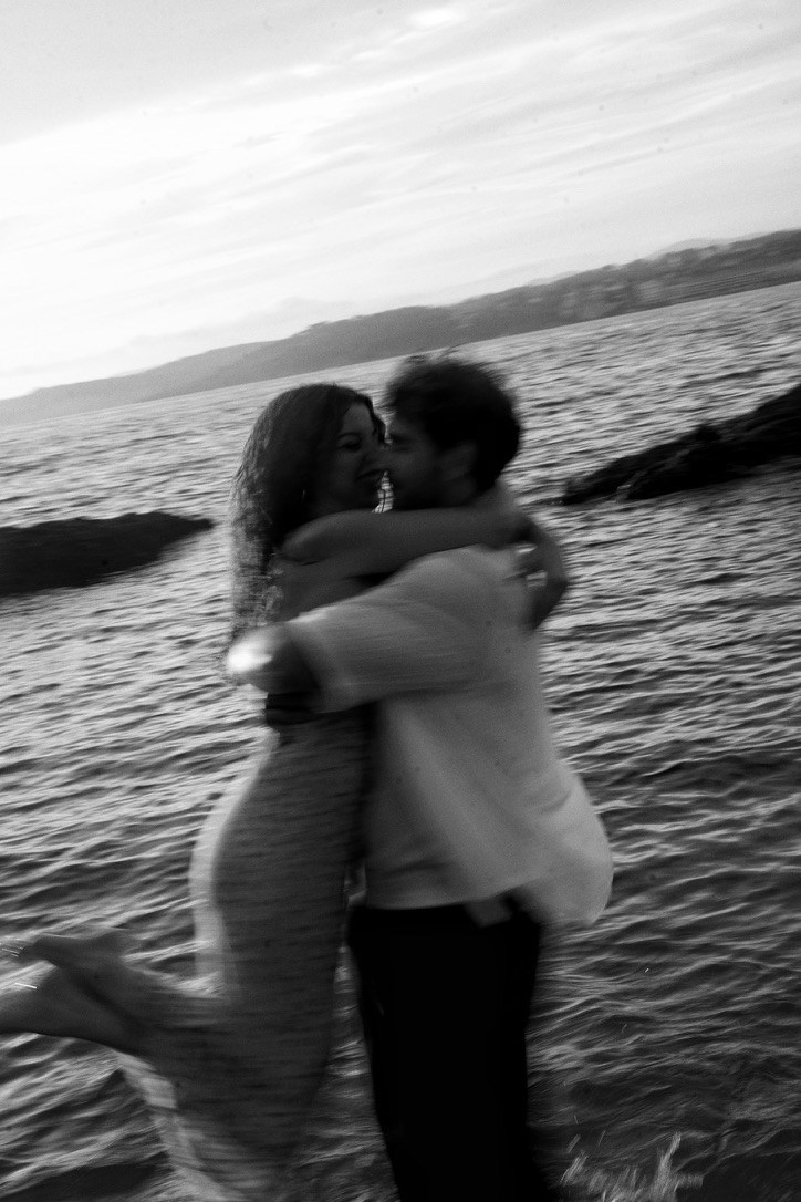 Un couple s’embrasse en noir et blanc au bord de l’eau