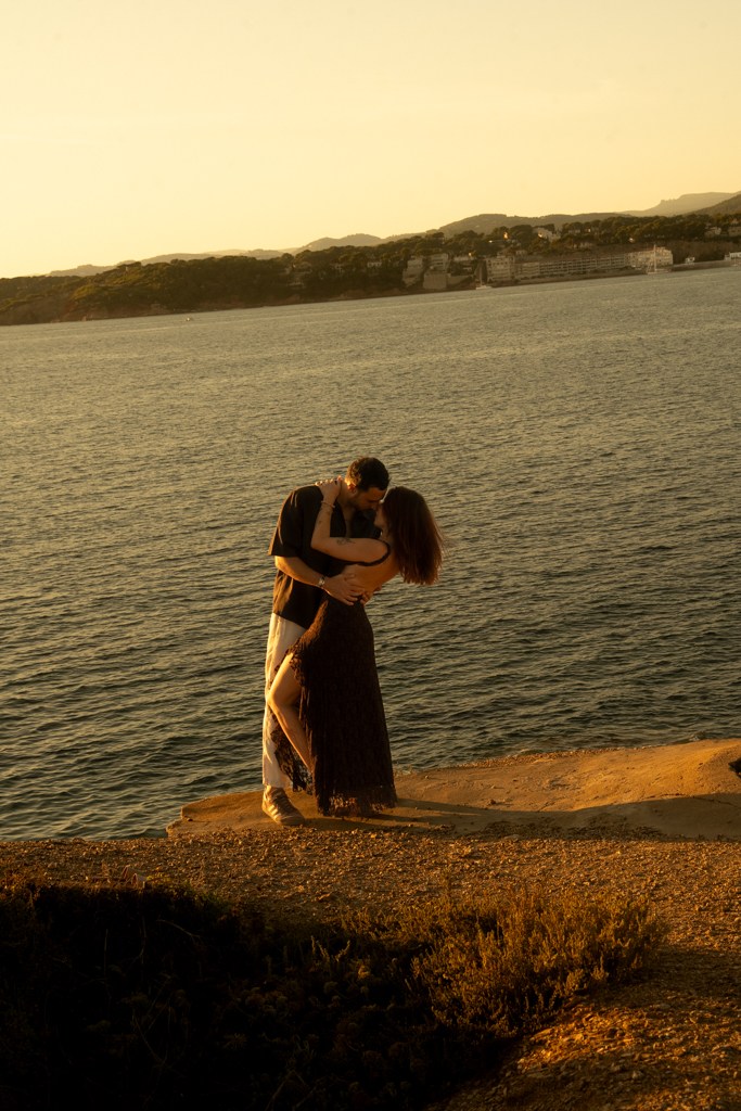 Un couple se serre dans les bras face à la mer