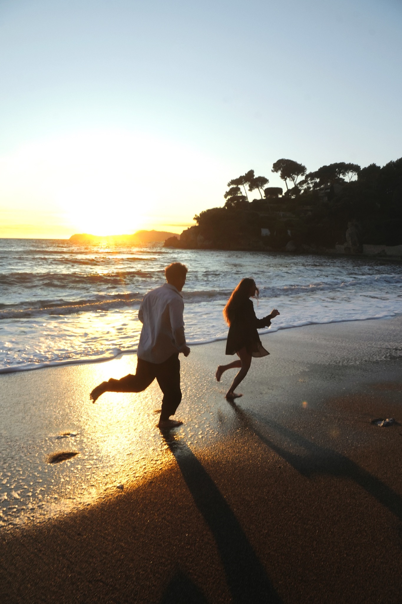 Un couple marche ensemble dans la lumière du coucher de soleil