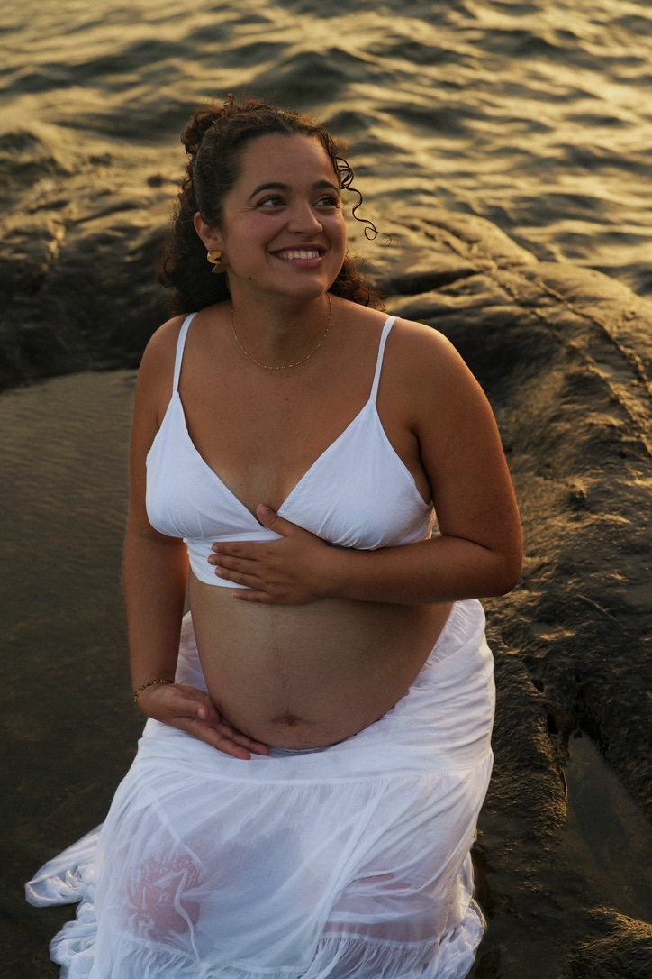 Une future maman profite de la lumière dorée au bord de l’eau