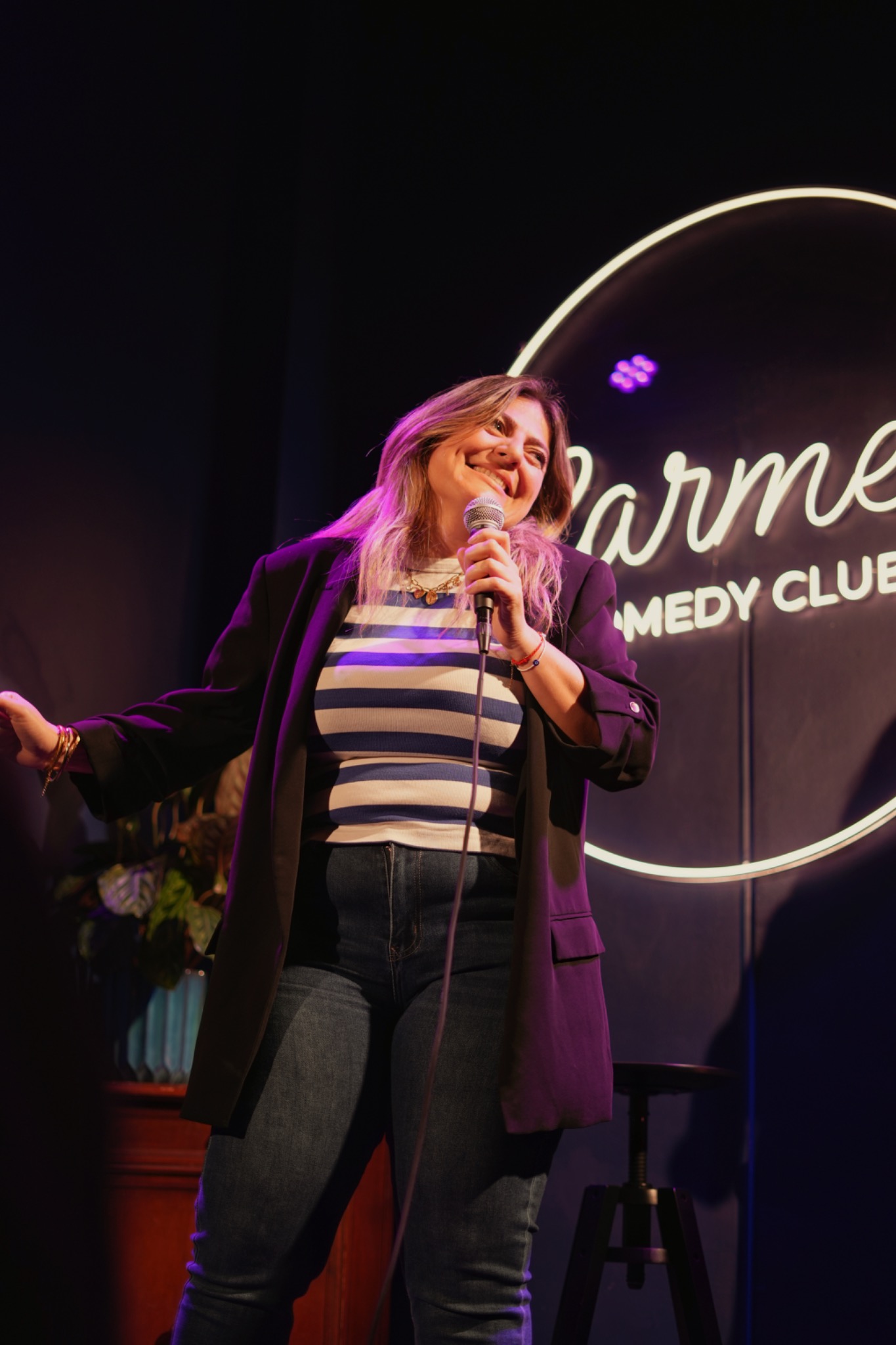 Une artiste prend la parole sur la scène du Carmen Comedy Club