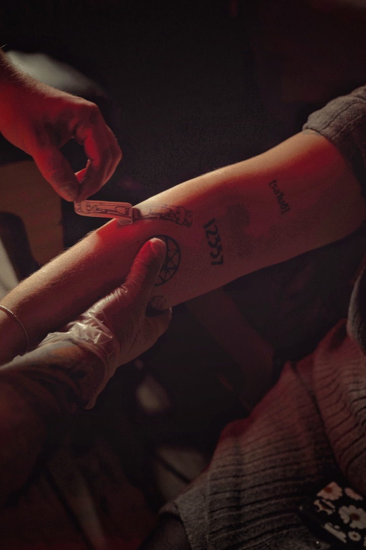 Un tatouage se dessine sur le bras d’une cliente