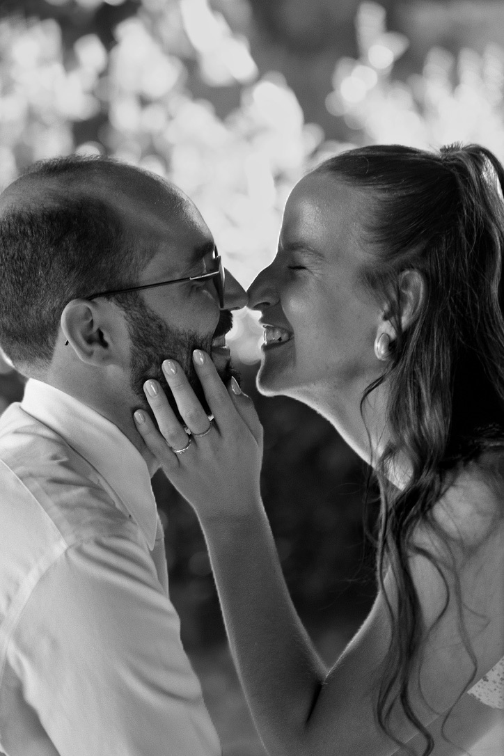 Les mariés échangent un baiser tendre, photographié en noir et blanc.