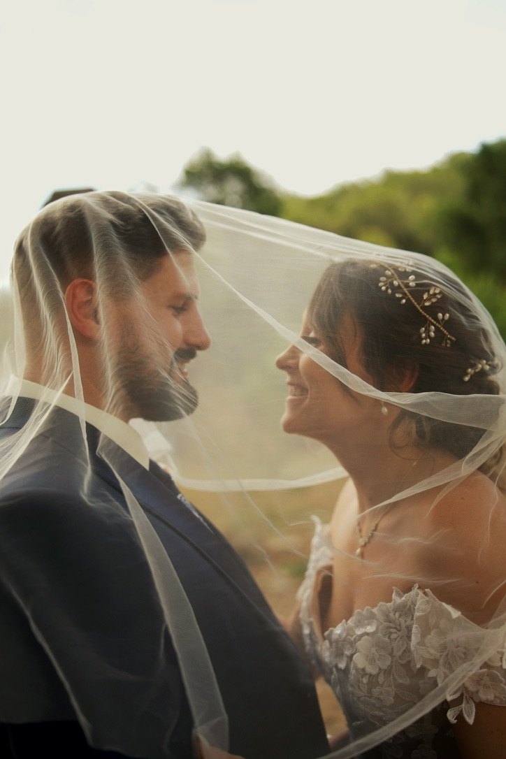 Les mariés sourient l’un à l’autre sous leur voile