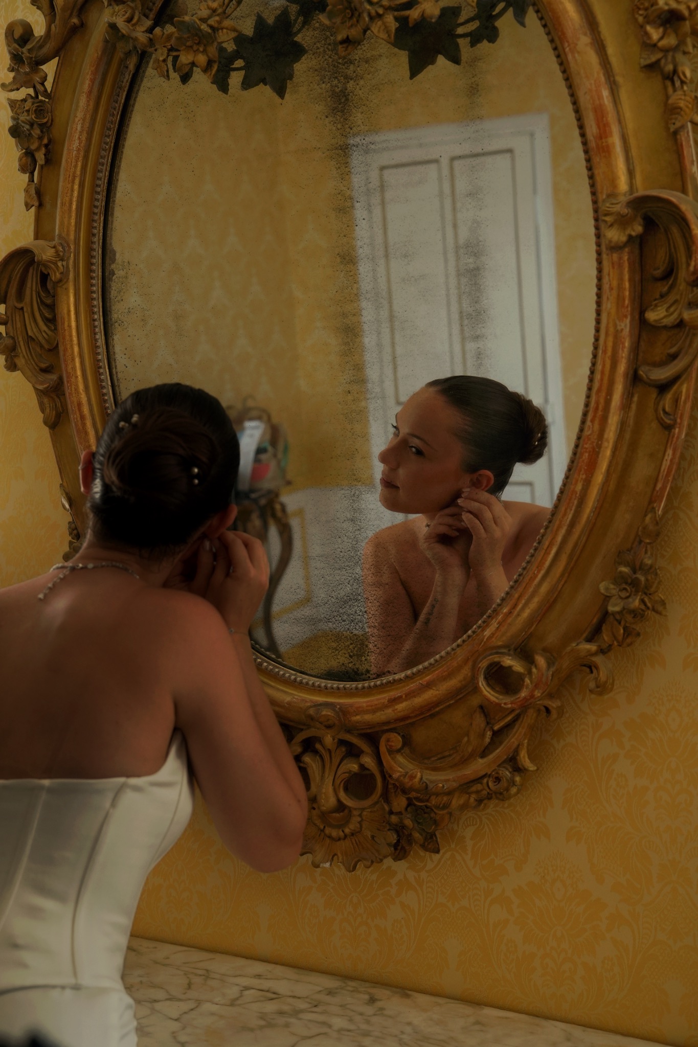 La mariée se prépare devant un grand miroir
