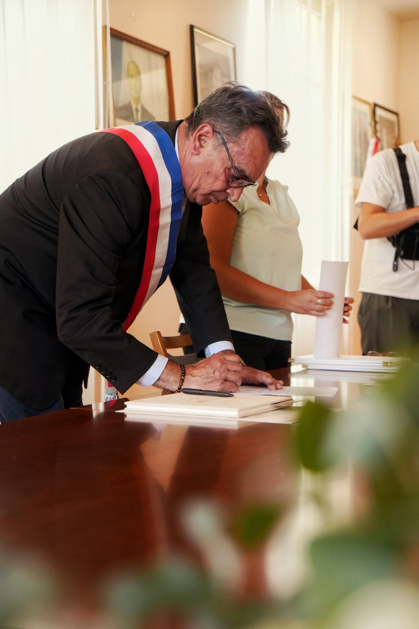 Un proche signe le registre après les mariés