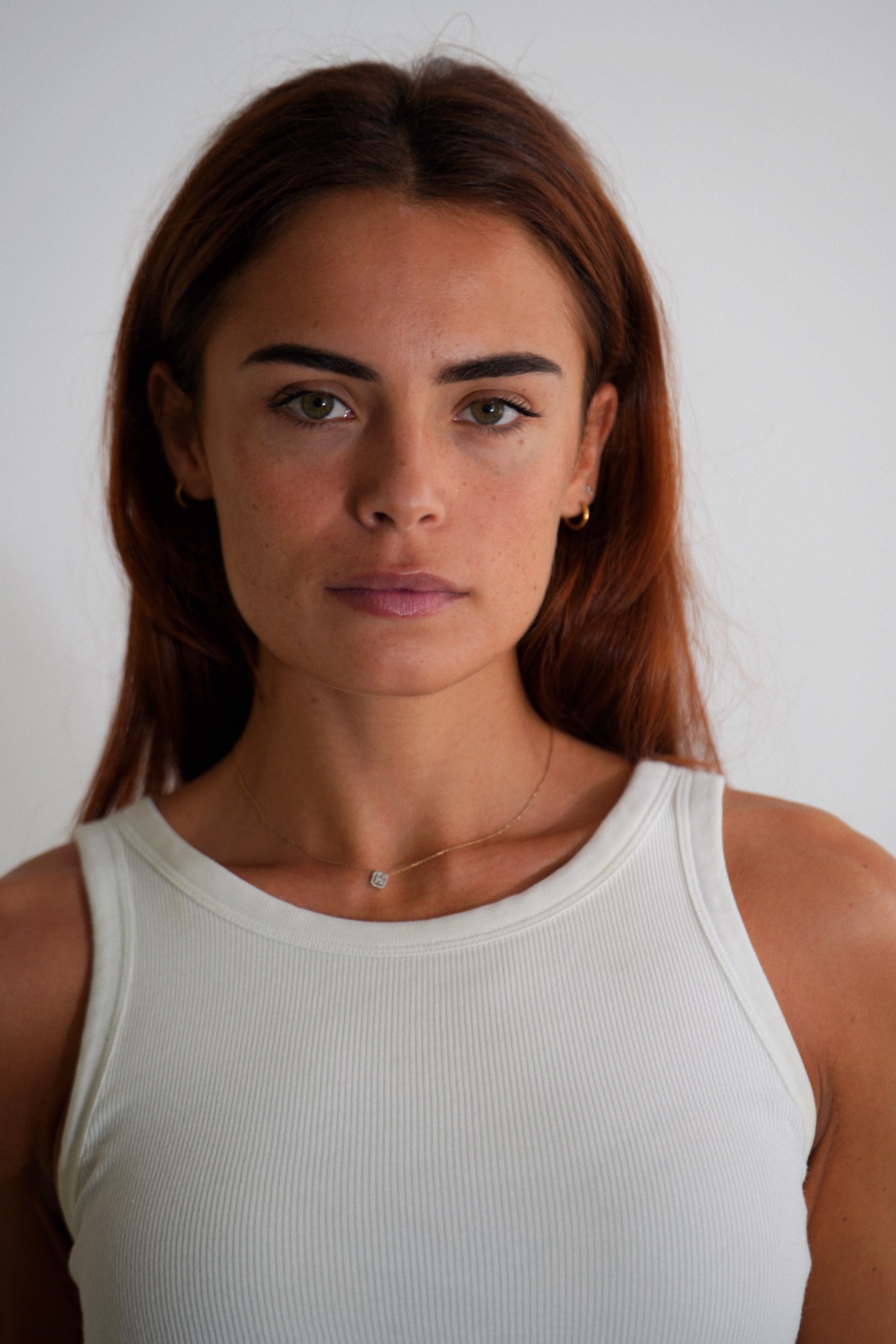 Portrait en studio en buste, regard face à l’objectif sur fond clair.